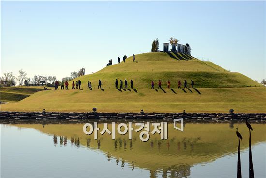 제16회 순천만 갈대축제가 17일부터 19일까지 사흘간 순천만정원, 순천만, 시내일원에서 '순천만 갈대愛, 순천맛을 느끼다!'주제로 열리고 있는 가운데 18일 순천만정원을 찾은 관광객들이 호수공원을 걸으면서 가을 정취를 만끽하고 있다. 호수공원 언덕이 물에 반영되면서 우주선을 연상케하고있다.