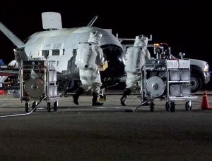 ▲X-37B가 착륙하고 두꺼운 안전복을 착용한 기술자들이 다가서고 있다.[사진제공=뉴사이언티스트/U.S. Air Force]
