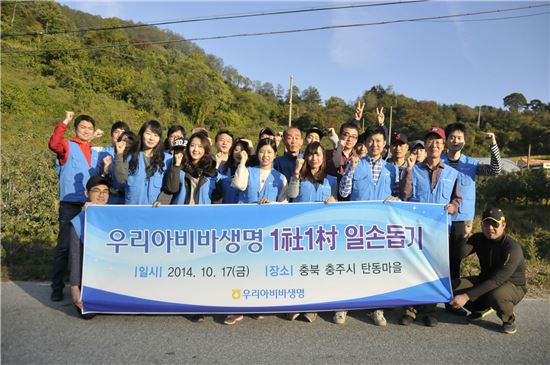 우리아비바생명 임직원들이 충북 충주시 탄동마을을 방문해 일손 돕기 활동을 실시하면서 기념촬영을 하고 있다.