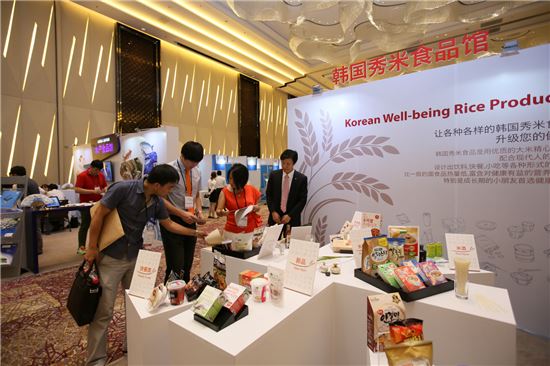▲지난 6월 중국 상하이에서 개최된 '2014 상하이 케이푸드 전시회'에서 농수산식품유통공사 직원들이 쌀가공식품을 설명하고 있다.