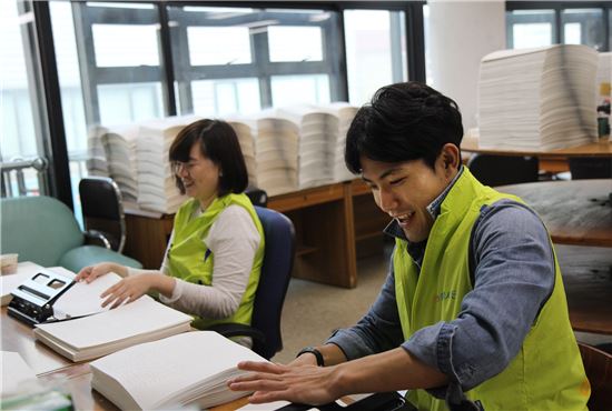 NH농협생명 직원들이 서울 시각장애인 복지관에서 점자책 제본 작업을 하고 있다. 
