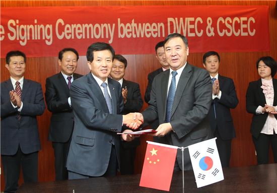 박영식 대우건설 박영식 사장(왼쪽)과 CSCEC 황커쓰 8국 회장이 전략적 제휴 협약서에 서명하고 악수를 나누고 있다.