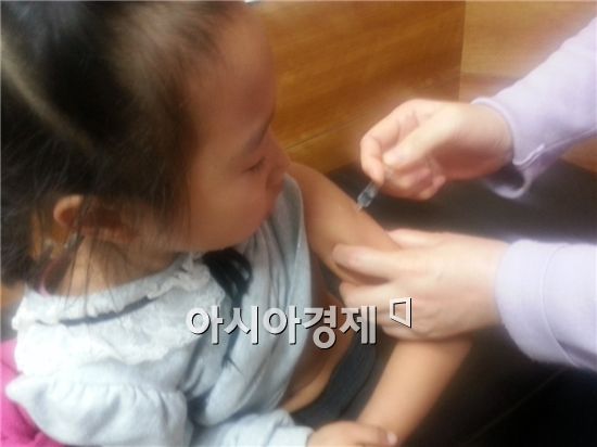 한 어린이가 독감예방주사를  맞고 있다.