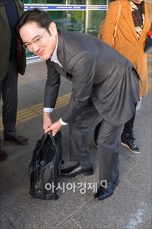 이재용 부회장이 해외출장을 마치고 김포국제공항에 나오면서 직접 서류가방을 챙기고 있다.<자료사진>