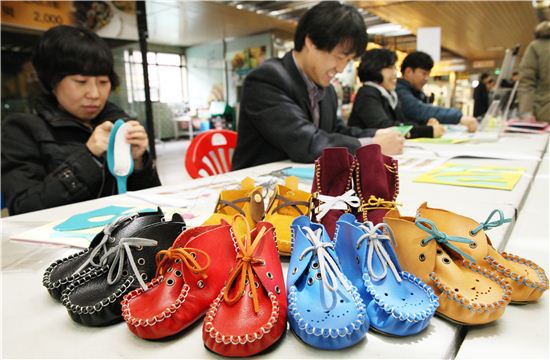 시민들이 아기모카신 만들기 체험에 참여하고 있는 모습