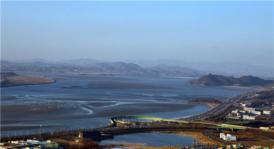 한강과 임진강이 만나는 합수지점 넘어 북한쪽 개풍군이 아스라이 들어온다. 앞쪽에는 자유로가 이어지고 오른쪽 끝에 통일전망대가 있다.
