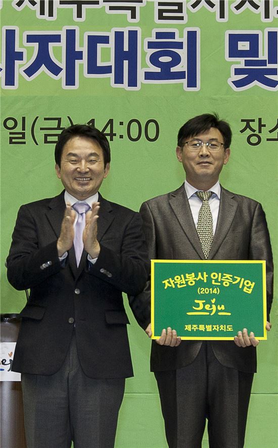 12일, 제주시 한라체육관에서 진행된 제주특별자치도 자원봉사자대회 및 전국체전 해단식에서 제주신라면세점 이상진 부점장(사진 오른쪽)이 원희룡 도지사로부터 자원봉사 친화기업 인증패를 수여 받은 후 기념촬영을 하고 있다.