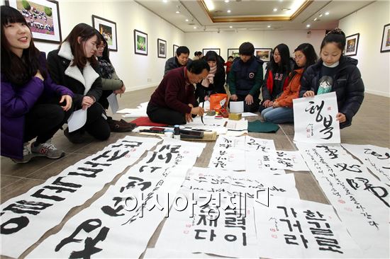 광주 북구 일곡도서관 갤러리에서는 8일 겨울방학과 신년 특별 프로그램으로 서예로 신년 다짐쓰기 행사가 열려 강사가 붓글씨로 도서관을 이용하는 아이들과 주민들을 대상으로 신년 소망과 가훈 등을 써주고 있다. 사진제공=광주시 북구

  
