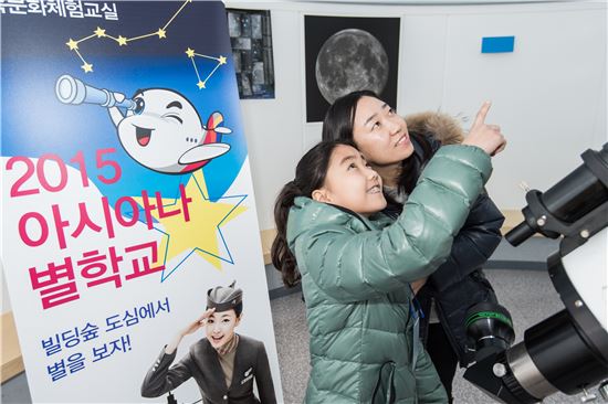 지난 23일 서울 용산에 위치한 '과학 동아 천문대'에서 실시한 아시아나 별학교 행사에서 한 참가자 가족이 천체망원경을 통해 별자리 관측을 하고 있다.