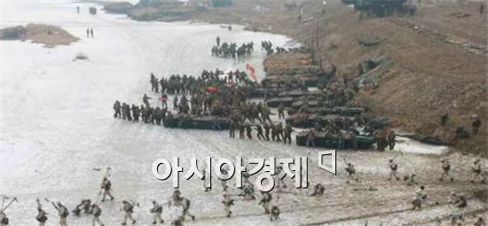 북한군이 도하훈련을 벌이고 있다.설상복을 입은 스키부대 뒤로 군인들이 뜰다리를 옮기고 있다.