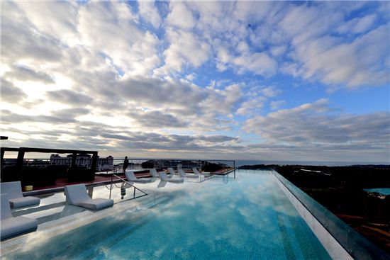 국내특 1급 호텔 최초로 선보이는  '스카이피니티 풀'로 불리는 루프톱 풀은 환상이다. 뜨끈한 야외수영장에 몸을 담그면 제주 하늘이 품에 안긴다 