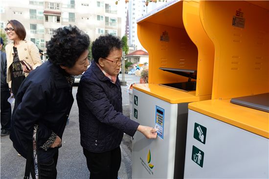 동대문구 주민들이 주택단지에 설치된 RFID(세대별종량제) 계량기에서 카드를 이용해 음식쓰레기 버리는 방법을 시연하고 있다. 
