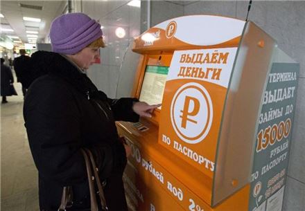러시아 모스크바 쿠르스크 역에서 한 중년 여성이 ATM에서 돈을 빌리기 위해 개인 정보를 입력하고 있다. /사진: Bloomberg