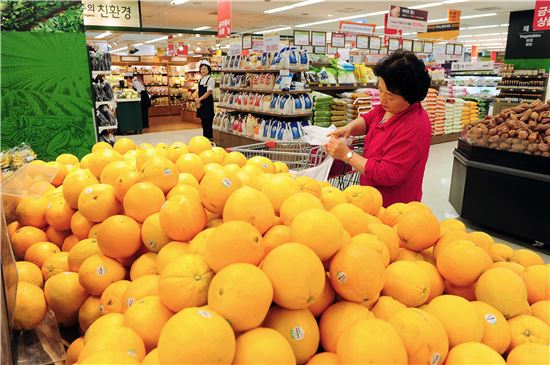 한 소비자가 이마트 매장에 방문해 수입산 오렌지를 고르고 있다.