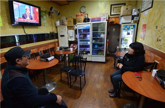 평일 저녁, 손님이 뜸한 가운데 식당 주인이 TV를 바라보고 있다. 사진=최우창 기자 smicer@