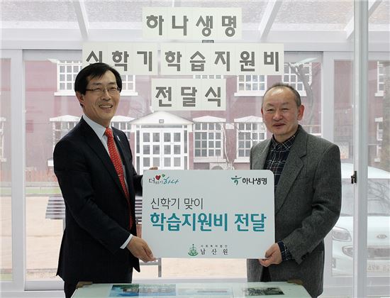 김인환 하나생명 사장(왼쪽)이 아동양육시설 '남산원'에 학습지원비를 전달하면서 기념촬영을 하고 있다.