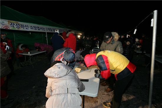 지난 1월1일 개화산 해맞이 행사에서 주민들이 소망엽서를 쓰고 있다.