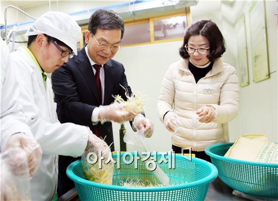 장만채 교육감이 순천선혜학교에서 친환경콩나물을 담고있다.