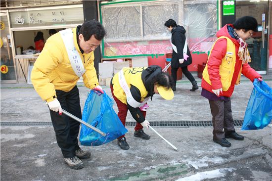 박겸수 강북구청장이 주민들과 함께 거리 청소를 하고 있다.