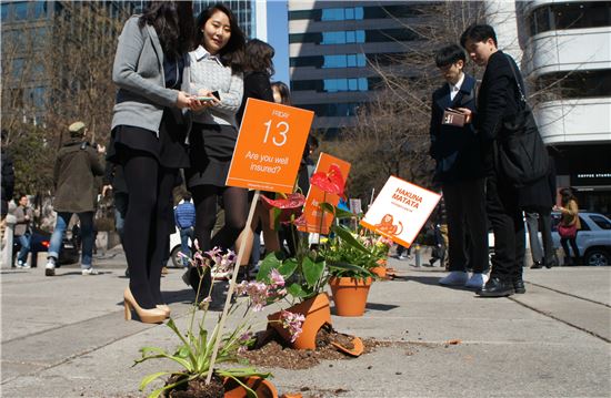 ING생명이 서울 청계천 일대에서 진행한 고객 이벤트에 참여한 시민들이 깨진 화분과 온전한 화분들을 유심히 보고 있다. 