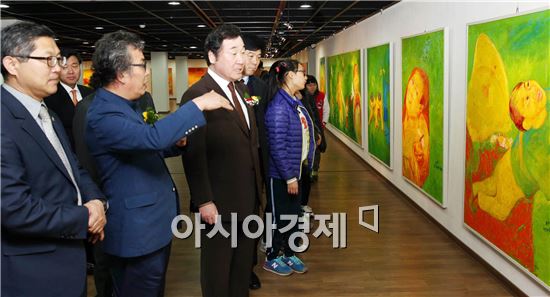 이낙연 전남도지사가 13일 목포문화예술회관에서 열린 국내 서양화가 최초 UN본부 전시회 초청기념 김근태 화백 국내 순회전시회 개막식에 참석, 김근태 화백(왼쪽 두 번째)으로부터 작품 설명을 듣고 있다. 사진제공=전남도