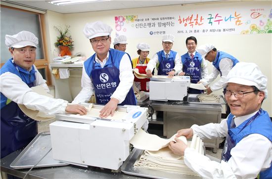 24일 서울 종로구 숭인동에 위치한 대한적십자사 종로중구희망나눔봉사센터에서 진행된 독거어르신 및 저소득 가정을 위한 국수나눔 행사에서 신한은행 임원 및 본부장들이 국수 가락을 뽑는 모습.