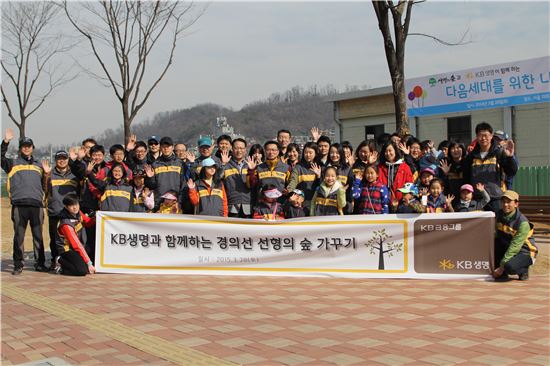 KB생명 직원 및 가족 70여명이 서울 마포구 상암동 경의선 폐선부지 일대에 나무심기 활동에 참여해 기념촬영을 하고 있다.
