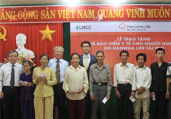 백종국 한화생명 베트남 법인장(왼쪽 여섯번째)과 현지 관계자들이 건강보험증 전달식을 갖고 기념촬영을 하고 있다.
