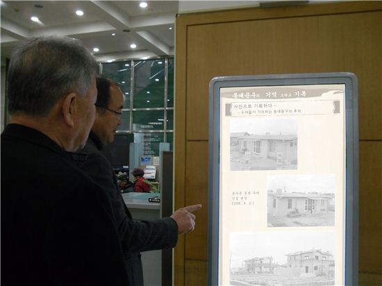지난해 민원실 DID게시판을 활용해 열린 ‘디지털 기록 전시회‘에서 직원들이 동대문구의 사진 기록물을 살펴보고 있다.
