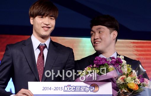 이승현(오른쪽)이 전년도 신인선수상 수상자 김종규에게 상패를 받고 기뻐하고 있다.[사진=김현민 기자] 
