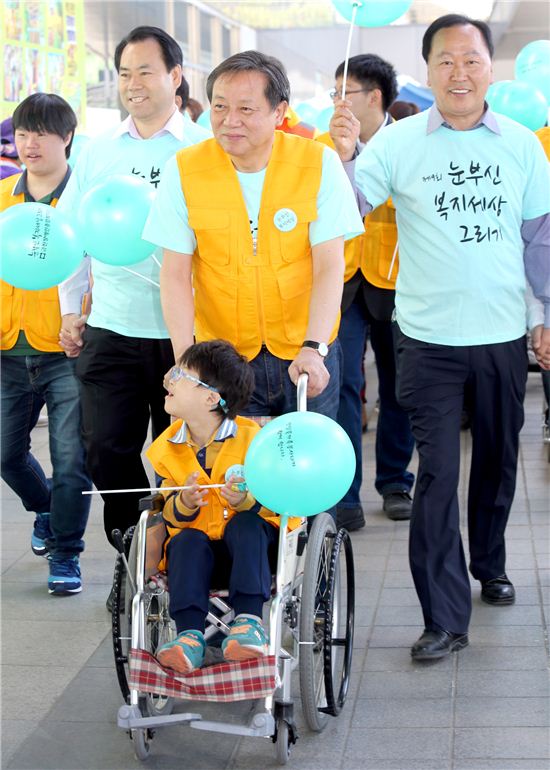 장애아동이 탄 휠체어를 밀어주며 걷기대회를 시작하는 차성수 금천구청장

