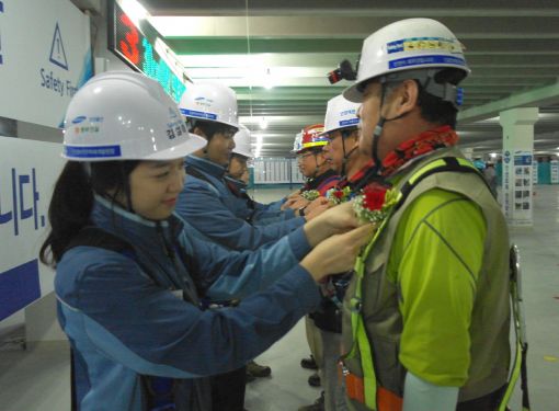 지난 6일 삼성물산 안양덕천재개발 현장에서 삼성물산 직원들이 협력사 근로자에게 감사의 마음을 담아 카네이션을 달아드리고 있다.