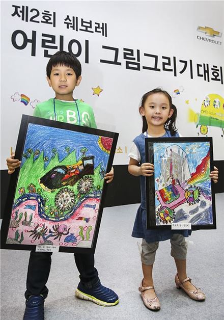 한국지엠이 주최한 그림대회에서 유치부와 초등부 1등 수상 어린이들이 본인들의 작품을 들고 포즈를 취하고 있다.