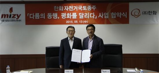▲이태종 한화 방산부문장(왼쪽)이 13일 서울 장교동 사옥에서 열린 서울시립청소년문화교류센터와의 자전거 국토종주 업무협약식에서 백상현 소장과 기념 촬영을 하고 있다.