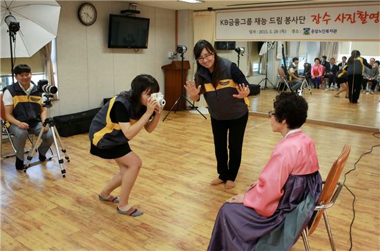 KB금융그룹 재능드림봉사단이 노인들의 만수무강을 기원하는 장수사진 촬영을 하고 있다.