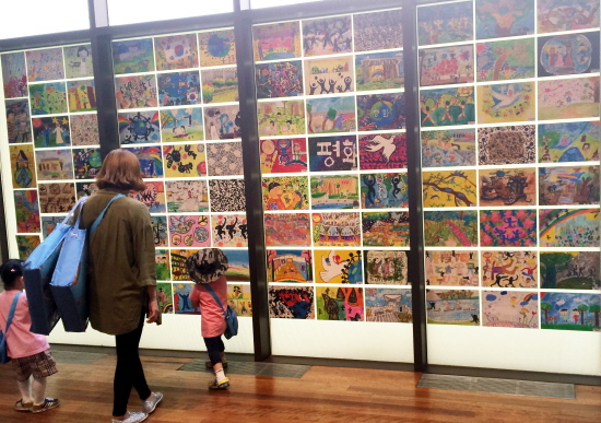 ‘제2회 이응노 미술대회’ 수상작품 전시회장. 엄마와 함께 온 어린이가 그림작품을 보고 있다.