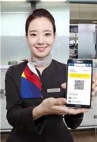 ▲아시아나항공 공항 직원들이 인터넷/모바일 탑승권을 들어 보이고 있다. 