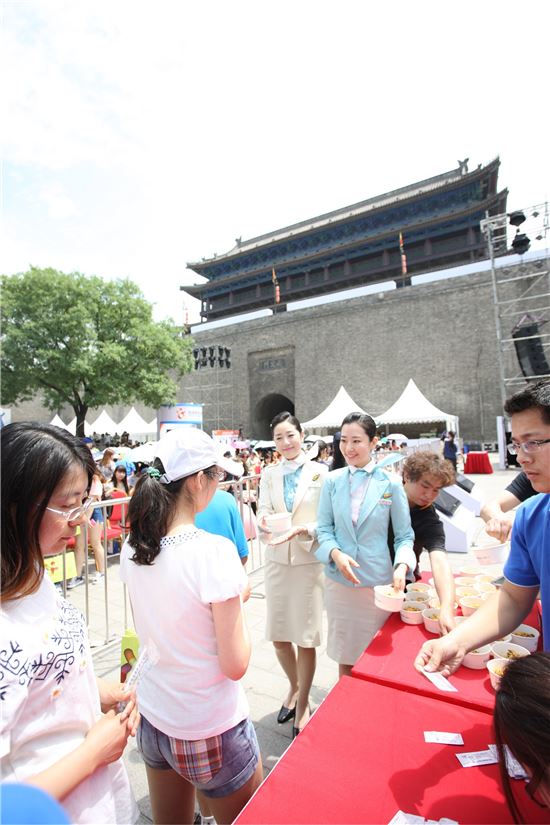 행사장을 찾은 현지 관람객에게 대한항공 승무원들이 조리된 비빔밥을 나눠주고 있다. 