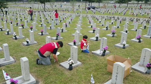 지난 달30일 롯데건설 임직원 가족들이 서울현충원에서 묘역 단장을 하고 있다.