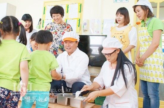 <조영표 광주광역시의회 의장이 10일 열린 '어린이집 개방의 날' 행사에서 배식도우미 역할을 맡아 아이들의 점심을 챙겨주고 있다.>