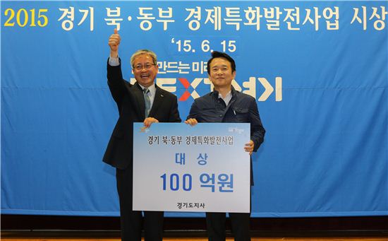 이재홍 파주시장(왼쪽)이 15일 열린 경기북동부 경제특화발전사업 시상식에서 대상을 받은 뒤 손을 치켜올리며 좋아하고 있다.  