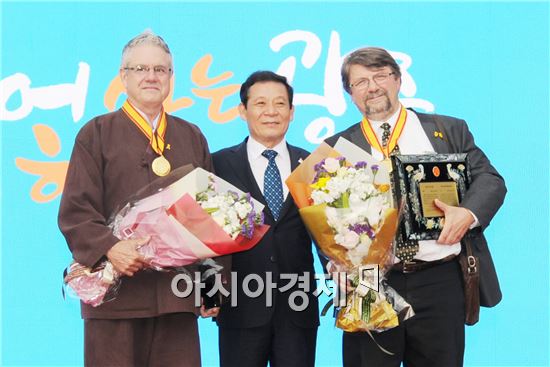 티모시 스콧 샤록이 지난 5월21일 국립아시아문화전당 앞 5·18민주광장에서 열린 광주시민의 날 기념식에서 윤장현 광주광역시장으로 부터 명예시민증을 받고 기념촬영을 하고 있다. (왼쪽부터 조지 카치아피카스, 윤장현 광주광역시장, 티모시 스콧 샤록)