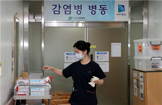 수원병원 내 감염병동 입구에서 의료진이 의료기구를 챙기고 있다.