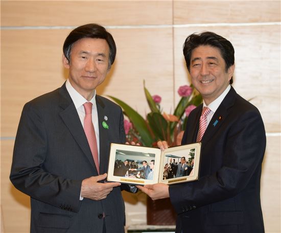 22일 아베 신조 일본 총리를 예방한 윤병세 외교부 장관(왼쪽)은 아베 총리의 부친인 아베 신타로 전 외무상의 방한 사진을 선물했다.