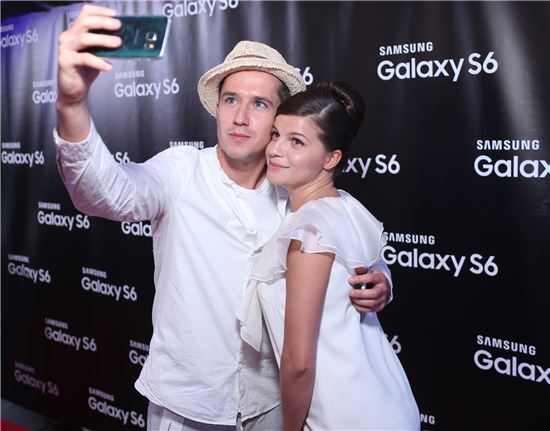 '갤럭시S6 엣지 스페셜 에디션' 자선경매 행사에 참석한 러시아 배우 예고르 코레쉬코프(사진 왼쪽)와 아그니야 쿠즈네초바가 갤럭시S6로 셀피 촬영을 하고 있다.