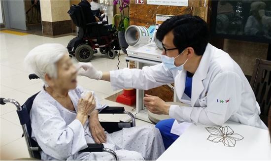 ◇ 김정민 부천 베스티안병원 대표과장(오른쪽)이 어르신 환자를 진료하고있다. 