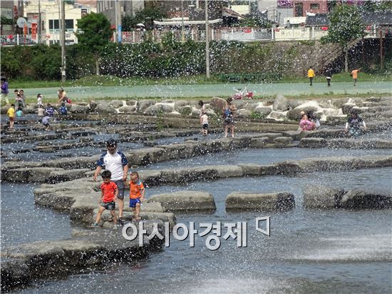 [포토]장흥 탐진강 징검다리에서 무더위 식히는 가족들