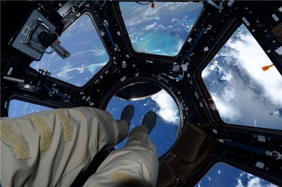 ▲스콧 켈리가 '큐폴라'에서 발 아래 펼쳐지는 지구를 지켜보고 있다.[사진제공=NASA/Scott Kelly]