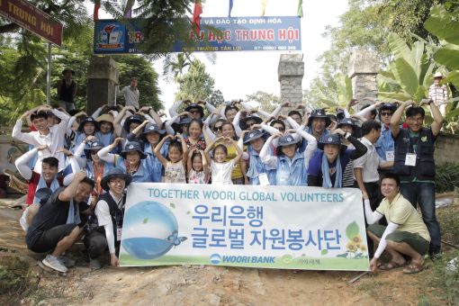 지난 7일 베트남 현지에서 우리은행 글로벌 자원봉사단 직원들이 지역주민들과 기념촬영을 하고 있다.