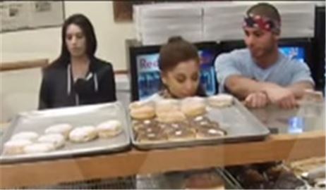 아리아나 그란데가 도넛가게서 진열된 도넛을 핥고 있다. 사진=TMZ